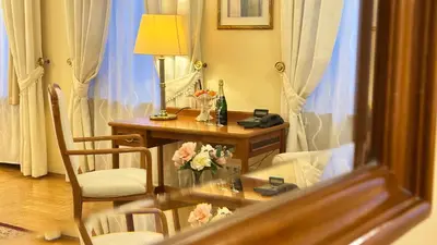 a room with a desk and a table with flowers on it at FLEUR DE LIS HOTEL in Prague