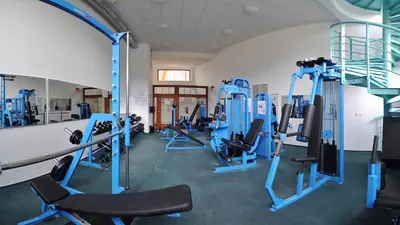 a gym with a lot of treadmills and ellipticals at Hotel VZ Měřín in Merin