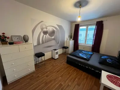 a bedroom with a bed and a dresser at MONFas APARTMENT GARDEN CITY in Prague
