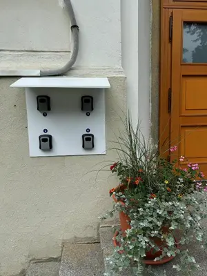 a white mailbox on the side of a building with a plant at Penzion Zahrada Čech in Litoměřice
