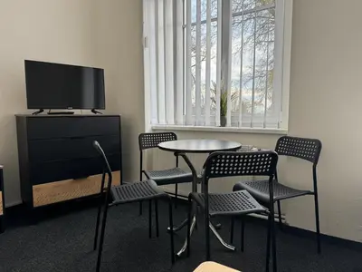 a room with a table and chairs and a tv at Penzion Zahrada Čech in Litoměřice