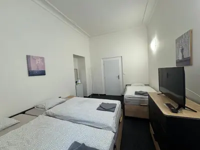 a room with two beds and a flat screen tv at Penzion Zahrada Čech in Litoměřice