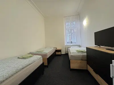 a room with three beds and a flat screen tv at Penzion Zahrada Čech in Litoměřice