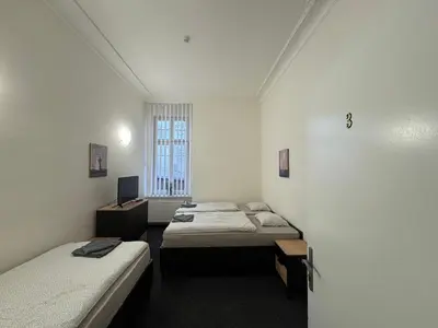 a room with three beds and a window at Penzion Zahrada Čech in Litoměřice