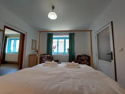 a bedroom with a large bed with two towels on it at Modré okno in Kozojedy