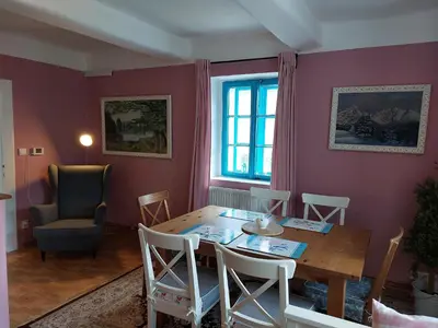 a dining room with a wooden table and chairs at Modré okno in Kozojedy