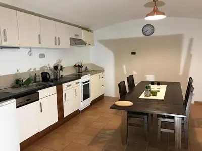 a kitchen with a table and a clock on the wall at 3 Bed Flat - Sleeps 20 - Smoking room - Wifi in Prague