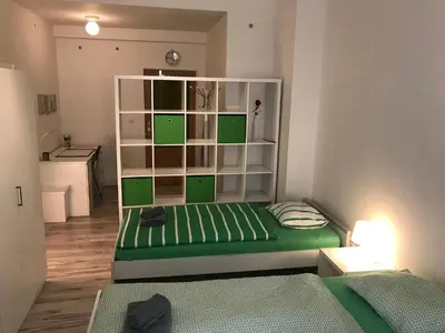 a small room with a green bed and shelves at 3 Bed Flat - Sleeps 20 - Smoking room - Wifi in Prague