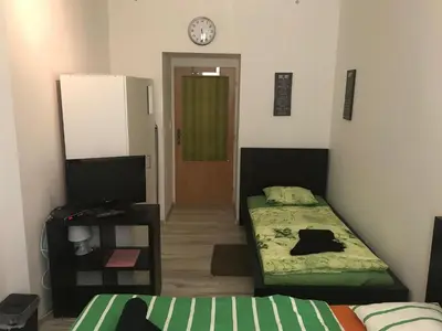 a bedroom with two beds and a television and a clock at 3 Bed Flat - Sleeps 20 - Smoking room - Wifi in Prague