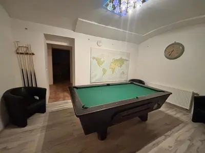 a room with a pool table and a clock on the wall at 3 Bed Flat - Sleeps 20 - Smoking room - Wifi in Prague