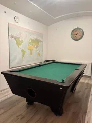 a pool table in a room with a clock on the wall at 3 Bed Flat - Sleeps 20 - Smoking room - Wifi in Prague