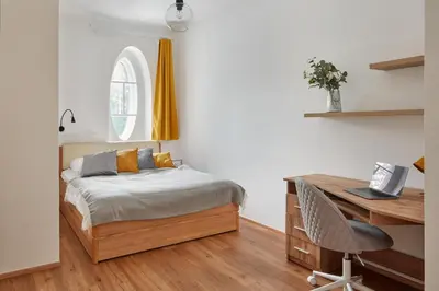 a bedroom with a bed and a desk with a laptop at Prague Days - Modern Apartments w Easy City Access in Prague