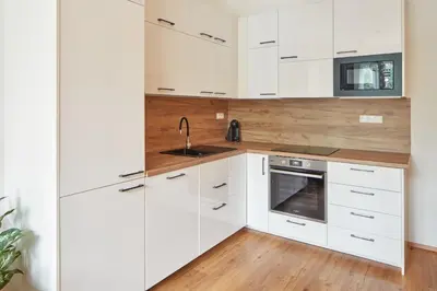 a white kitchen with white cabinets and a sink at Prague Days - Modern Apartments w Easy City Access in Prague