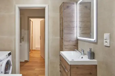 a bathroom with a sink and a washing machine at Prague Days - Modern Apartments w Easy City Access in Prague