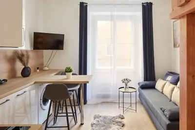 a living room with a table and a couch at Prague Days - Modern Apartments w Easy City Access in Prague