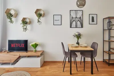 a dining room with a table and chairs and a tv at Prague Days - Modern Apartments w Easy City Access in Prague