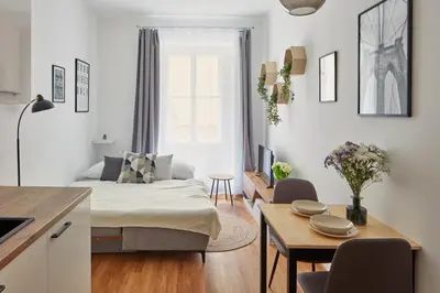 a living room with a bed and a table with chairs at Prague Days - Modern Apartments w Easy City Access in Prague
