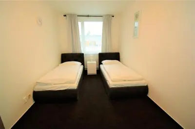 two beds in a small room with a window at Hotel Harfa in Prague