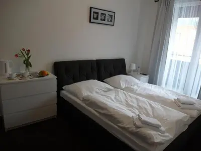 a bedroom with a bed with white sheets and a window at Hotel Harfa in Prague