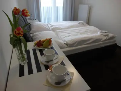a room with a bed and a table with coffee cups and fruit at Hotel Harfa in Prague