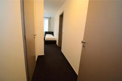 a hallway with a room with a bed and a door at Hotel Harfa in Prague