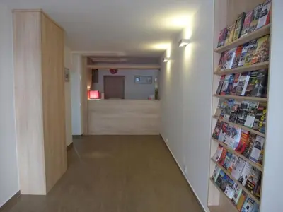 a hallway with a book shelf with magazines at Hotel Harfa in Prague
