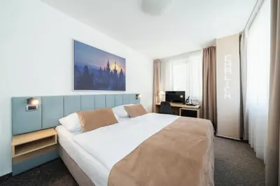 a hotel room with a large bed and a desk at Hotel Ehrlich Prague in Prague