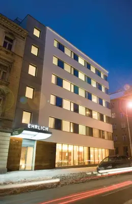 a tall building with lights on in a city at Hotel Ehrlich Prague in Prague