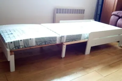 a white bed sitting on top of a wooden floor at Celý dům s vybavenou kuchyní, koupelna s vířivkou in Prague
