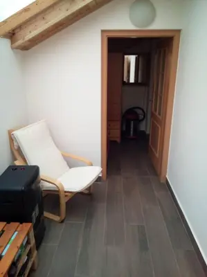 a living room with a chair and a table at Celý dům s vybavenou kuchyní, koupelna s vířivkou in Prague