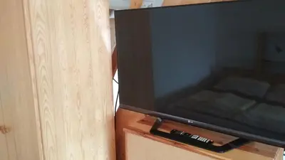 a television sitting on top of a wooden cabinet at Celý dům s vybavenou kuchyní, koupelna s vířivkou in Prague