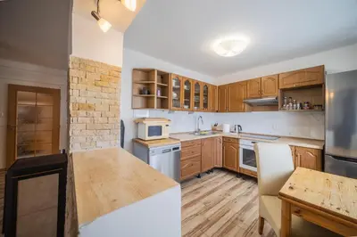 a kitchen with wooden cabinets and a counter top at Celý dům s vybavenou kuchyní, koupelna s vířivkou in Prague
