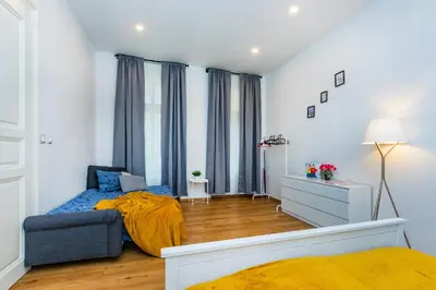 a bedroom with a bed and a couch in a room at Pat & Mat Apartment in Prague