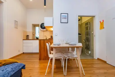 a dining room and kitchen with a table and chairs at Pat & Mat Apartment in Prague