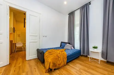 a bedroom with a bed with a blue blanket on it at Pat & Mat Apartment in Prague