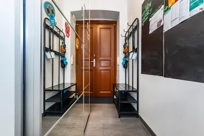 a hallway with a door and racks of hockey equipment at Pat & Mat Apartment in Prague