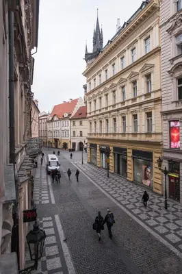 a group of people walking down a street with buildings at Opitzův dům in Prague