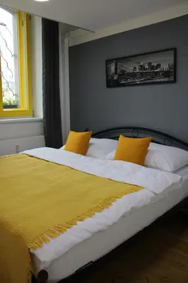 a bedroom with a large bed with two yellow pillows at LYLY APARTMENT - Modern apartment with free parking in Prague