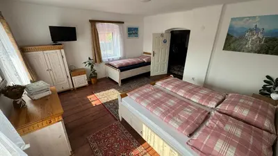 a bedroom with two beds and a tv at Ubytování Bauštel in Kochovice