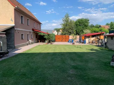 a yard with a large lawn in front of a house at Ubytování Bauštel in Kochovice
