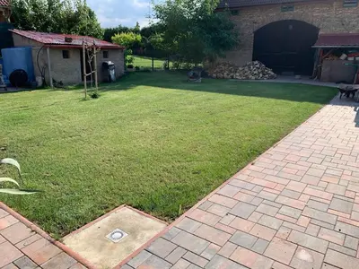 a backyard with a lawn with a brick walkway at Ubytování Bauštel in Kochovice