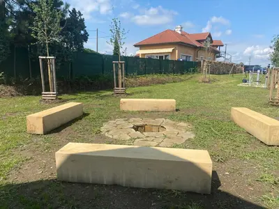 a park with stone benches in the grass at Penzion Rozkoš in Pruhonice