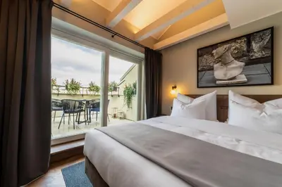 a bedroom with a large bed and a large window at The Viaduct - Suites & More in Prague