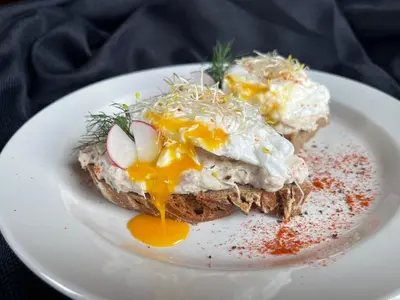 a plate of food with an egg and bread at The Viaduct - Suites & More in Prague