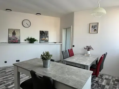 a dining room with a table and chairs and a clock at Apartmány Piller in Roudnice nad Labem