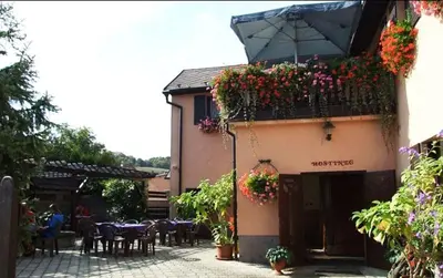a building with a balcony with flowers on it at Restaurace a penzion Na Růžku in Mořina