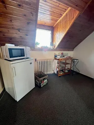 a room with a microwave on top of a refrigerator at Restaurace a penzion Na Růžku in Mořina