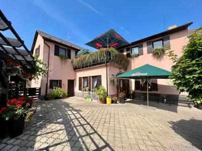a building with an umbrella and a patio at Restaurace a penzion Na Růžku in Mořina