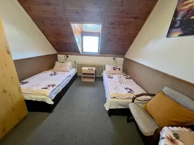 a small room with two beds and a window at Restaurace a penzion Na Růžku in Mořina