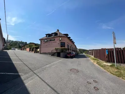an empty street with a building on the side of the road at Restaurace a penzion Na Růžku in Mořina